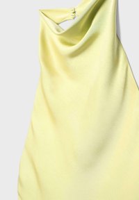 Haut sans manches jaune doux avec un col bénitier drapé et deux fermetures à boutons sur une épaule, sur un fond clair.