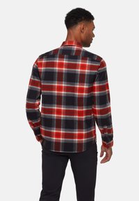 Camicia a quadri rossa e nera con dettagli grigi, realizzata in un tessuto con un leggero effetto testurizzato. Presenta un colletto button-down e maniche lunghe.