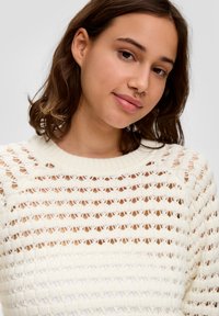 Weißer Strickpullover mit einem Durchbruchsdesign, horizontalen Streifen und einem gerippten Rundhalsausschnitt. Weiche Textur, leichtes Aussehen.