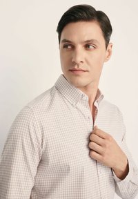 Koszula z guzikami, w jasny beżowy i biały wzór w kratkę, z kołnierzykiem, wykonana z teksturowanej tkaniny i dopasowanym kroju.