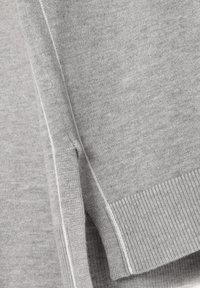 Grå sweater med en blød strikket tekstur, ribbede manchetter og en sømdetalje langs siden. Letvægts og afslappet design.