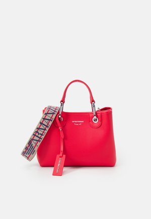 Red leather handbag with a textured finish, silver hardware, dual handles, and a patterned adjustable shoulder strap. Featuring a logo tag.