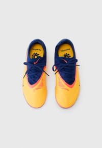 Bright yellow athletic shoes with a textured upper, navy blue accents, and pink detailing, featuring round laces and a cushioned insole.