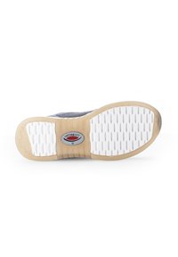 Sneakerzool met een witte, gestructureerde rubbersurface, bruine accenten en een rond logomerk in het midden. Voorzien van meerdere grippatronen.