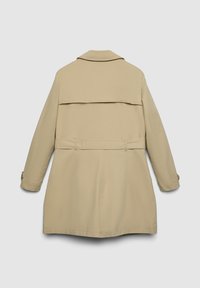 Trench-coat beige avec un détail cape au dos, manches longues et taille ceinturée. Tissu lisse avec des coutures minimales et sans quincaillerie visible.