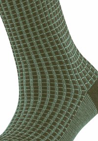 Calzini verde scuro con motivo a griglia in blu chiaro, caratterizzati da una texture liscia e dettagli rinforzati nel tallone e nella punta.