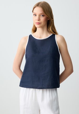 Top in lino blu navy con accenti bianchi nel collo e nelle aperture delle maniche. Vestibilità rilassata, orlo dritto, design minimalista senza motivi né embellishments.