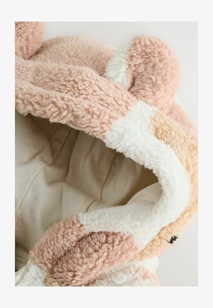 Ružová, nadýchaná mikina s krémovou podšívkou; obsahuje uši medveďa a mäkkú textúru, s farebným gradientom na vonkajšej strane.