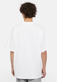 Hvid bomulds T-shirt med korte ærmer, afslappet pasform, rund halsudskæring og minimalistisk design. Glat tekstur uden synlige mønstre eller grafik.