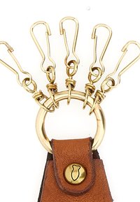Portachiavi in pelle marrone con anello rotondo in metallo dorato e cinque moschettoni dorati collegati da metallo a spirale. Presenta un dettaglio con bottone in ottone.