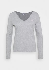 Grijze T-shirt met lange mouwen van zacht katoen. Heeft een V-hals ontwerp en een klein logo detail op de borst. Minimalistische stijl.