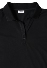 Polo noir avec un col court et deux boutons sous le col, montrant l’étiquette de marque indiquant "Cecil" au niveau du col.