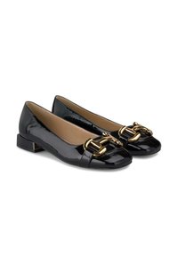 Chaussures plates en cuir verni noir avec un accent de chaîne dorée sur le bout, forme carrée et petit talon bloc. Texture lisse et finition brillante.