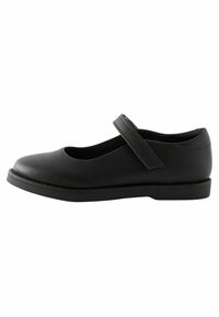 Chaussure Mary Jane en cuir noir avec un bout arrondi, une semelle plate et une simple sangle sur le cou-de-pied. Texture lisse et design minimaliste.