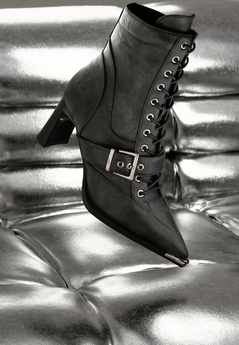 Mustad musta värvi nahast ankle boot, millel on tekstuur, terav nina, paeltega esiosa ja küljes dekoratiivne metallist pandla.