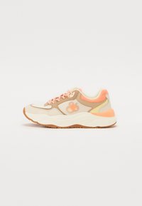 Sneaker with a beige upper, pink accents, mesh detailing, and textured sole. Features a rounded toe and contrasting lace design.