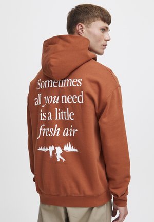 Sweat à capuche marron avec cordon de serrage, comportant un texte blanc : "Parfois, tout ce dont vous avez besoin, c'est un peu d'air frais" et des graphiques de randonnée au dos.
