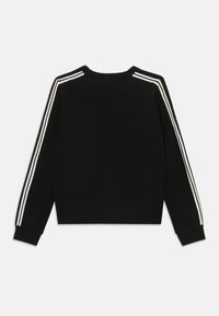 Maglione nero lavorato a maglia con strisce diagonali bianche sulle spalle, scollo rotondo e polsini e orlo a costine.
