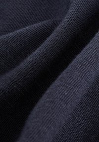 Tissu bleu marine foncé avec un tricot doux et texturé. La surface présente un motif subtil, affichant un aspect côtelé et une finition lisse.