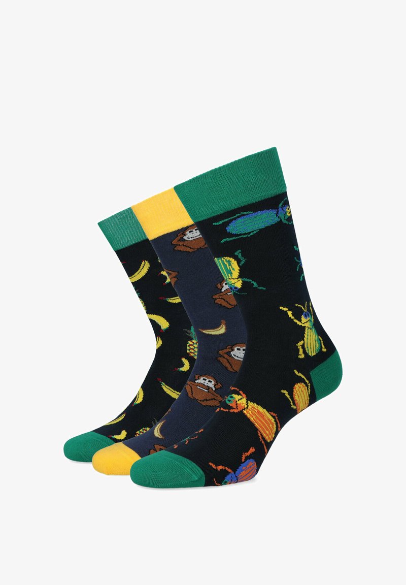 Trzy pary skarpetek załogowych z ciemnym tłem, zdobione motywami małp i owadów, z kontrastowymi ściągaczami oraz wzmocnionymi zielonymi palcami.
