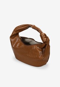 Bolso de mano tejido en marrón con un asa anudada, cuenta con un cierre de cremallera y un interior suave. Material texturizado con un patrón geométrico.