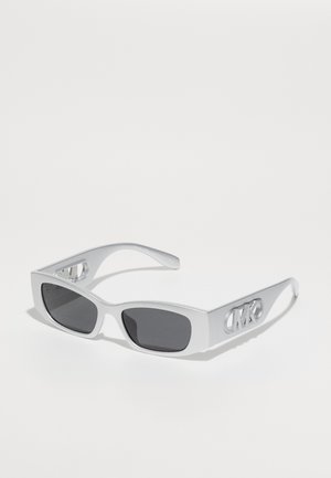 Lunettes de soleil argentées avec des verres rectangulaires, teintés foncés. Présentent une finition mate et un détail de logo sur le côté. Monture en acétate avec une forme géométrique.