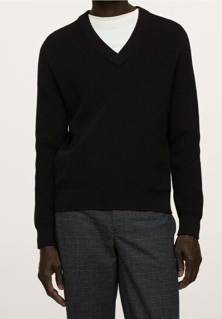 Zwarte v-hals trui van ribstof, met lange mouwen en een gestructureerd ontwerp. Draagt over een wit shirt met een rechte pasvorm.