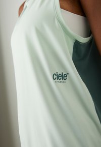 Light green athletic tank top with dark green accents. Features the "ciele ATHLETICS" logo. Soft, lightweight fabric with a relaxed fit.