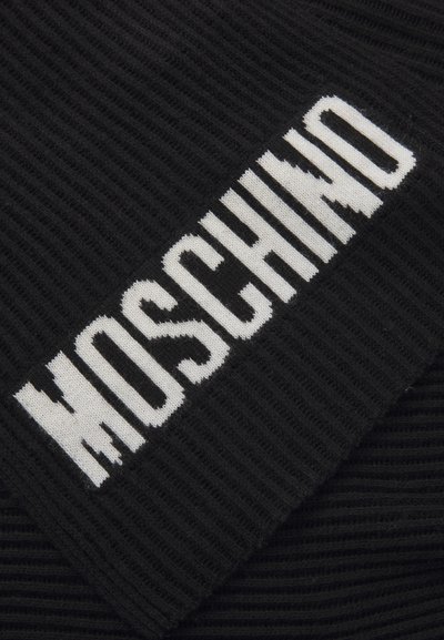 Melnā ribota adīta auduma ar izteiktu balto "MOSCHINO" logotipu. Teksts ir adīts materiālā ar treknu, blokveida stilu.