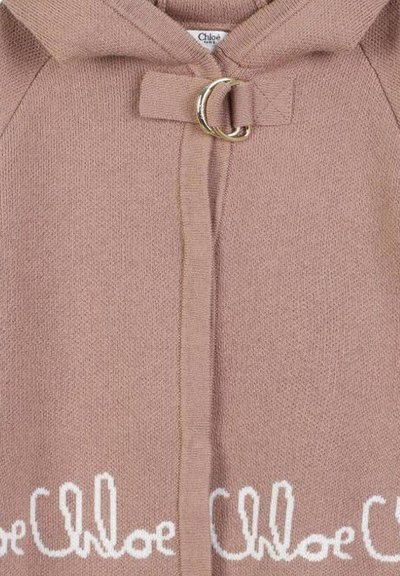 Cardigan lavorato a maglia rosa chiaro con cappuccio, chiusura a interruttore con anello dorato e ricamo bianco del logo "Chloé" lungo il fondo.