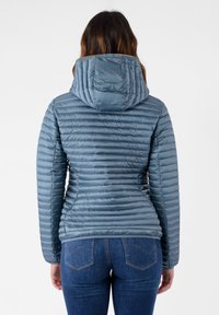 Giacca isolata azzurro chiaro con cappuccio, caratterizzata da un motivo trapuntato e una texture liscia. Completata con polsini elasticizzati e un design aderente.
