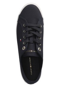 Zapatilla de lona navy con suela de goma blanca, puntera redonda, seis ojetes y detalles metálicos. Logo impreso en dorado en la plantilla.