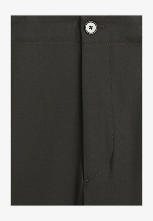 Tessuto grigio scuro con una texture, un singolo bottone bianco e dettagli di cuciture verticali e orizzontali visibili.