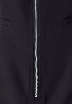 Črna jakna z matirano teksturo, s središnjim srebrnim zadrgo in dvema skritima stranskima žepoma.