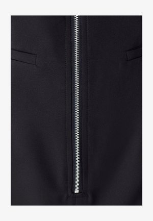 Mustat takki, jossa on mattapintainen kangas, keskellä hopeinen vetoketju ja kaksi piilotettua sivutaskua.