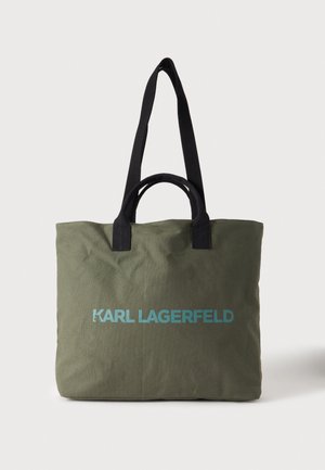 Маслиненозелена чанта тип „тоут“ Karl Lagerfeld с къси черни дръжки и дълги презрамки за рамо, показана на изчистен светъл фон.