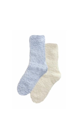 Par de calcetines peludos y de textura suave, uno azul claro y otro crema, exhibidos planos sobre un fondo blanco.