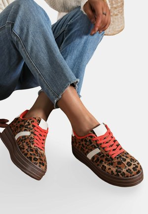 Baskets en imprimé léopard avec une semelle plateforme brune, des lacets orange et des accents blancs. Tissu texturé avec un embout arrondi et un profil bas.
