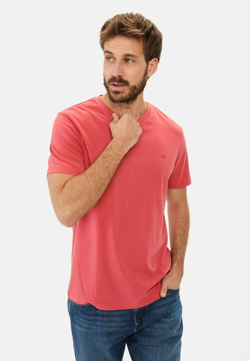 Koralfarvet bomulds T-shirt med rund hals og korteærmer. Udstyret med et lille logo på brystet. Sæt sammen med blå denim jeans.