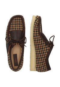 Ruskea ja beige houndstooth-kuvioiset kengät nahkaosilla, pyöreä muoto, nauhakiinnitys, paksut vaaleancremevärit pohjat ja teksturoitu pinta.