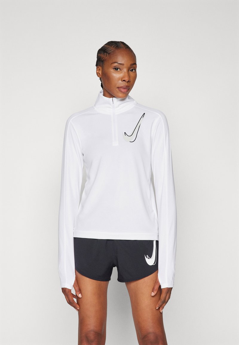 Pikkade varrukatega valge spordijakk, millel on pooltõmblukk ja must Nike'i kaubamärgi logo. Kombineeritud mustade lühikeste pükstega, millel on külgedel valge logo.
