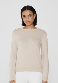 Beige Strickpullover mit langen Ärmeln, rundem Ausschnitt, gerippten Bündchen und Saum. Glatte Textur und leichtes Material; schlichtes Design.