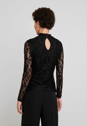 Black lace top featuring long sleeves, a mock neck, and a keyhole back with button detail. Designed with floral patterns and textured fabric.