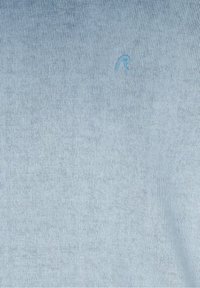 Tissu tricoté bleu clair avec une lettre "R" brodée en relief subtilement près du centre supérieur.