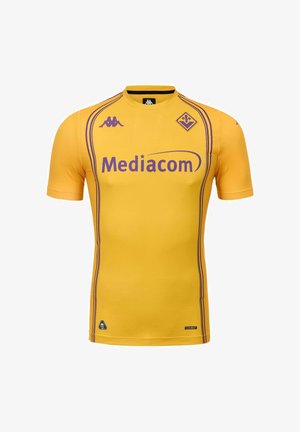 Maillot de football jaune à manches courtes avec le sponsor violet "Mediacom", logos Kappa et blason du club Fiorentina, avec des bandes violettes sur les côtés.