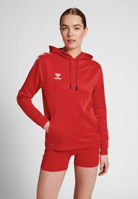 Rode hoodie met logo, trekkoordkap en voorzak, gecombineerd met rode shorts. Glad, lichtgewicht materiaal met blauwe schouderaccenten.