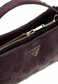Sac à main en simili cuir violet avec des motifs gaufrés et un logo doré. Dispose d'une fermeture éclair et d'un design lisse et structuré.