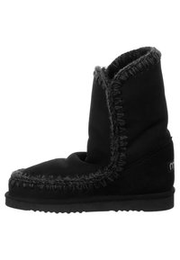 Stivale in suede nero con una parte superiore morbida e pieghevole, caratterizzato da cuciture a contrasto e una suola piatta in gomma. Design semplice senza elementi hardware in risalto.