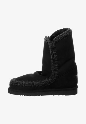 Czarne zamszowe botki z miękką, składanym cholewką, z kontrastowym przeszyciem i płaską gumową podeszwą. Prosty design bez wyraźnych akcesoriów.