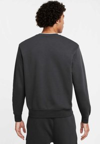 Felpa da uomo di colore grigio scuro con maniche lunghe, polsini e orlo a coste, texture liscia e design con scollo a girocollo.